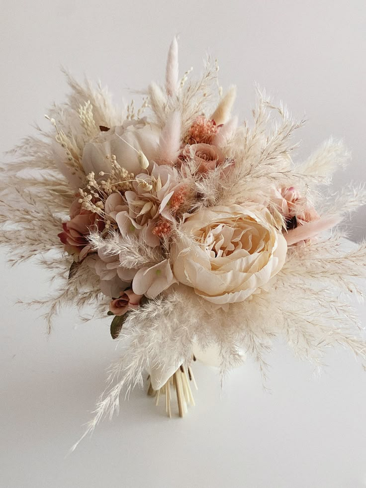 a bridal bouquet with feathers and flowers