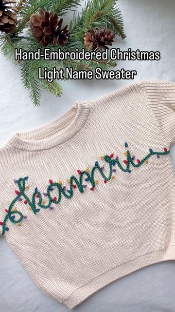 a white sweater with embroidered christmas name on it