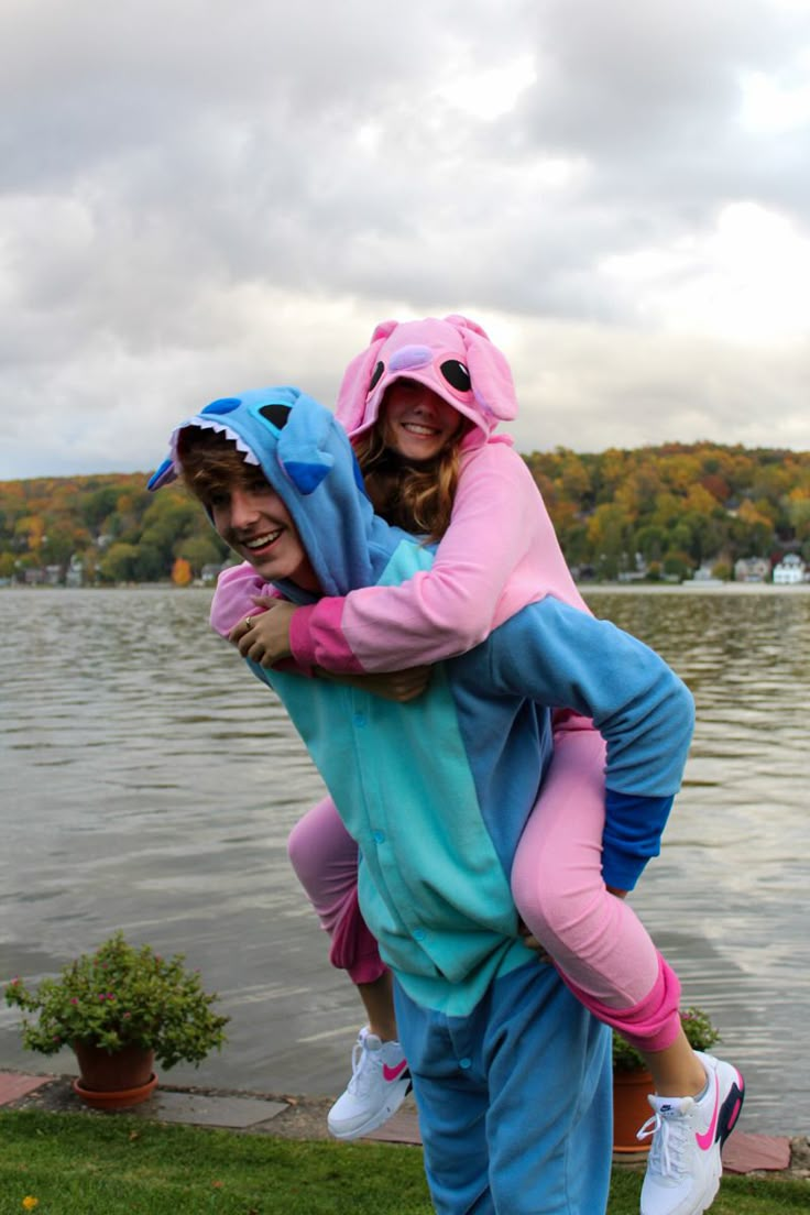 two girls in costumes hugging each other by the water