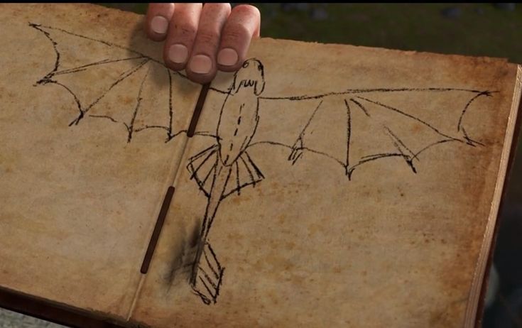 a hand is holding an old book with a bat drawn on it and a pencil