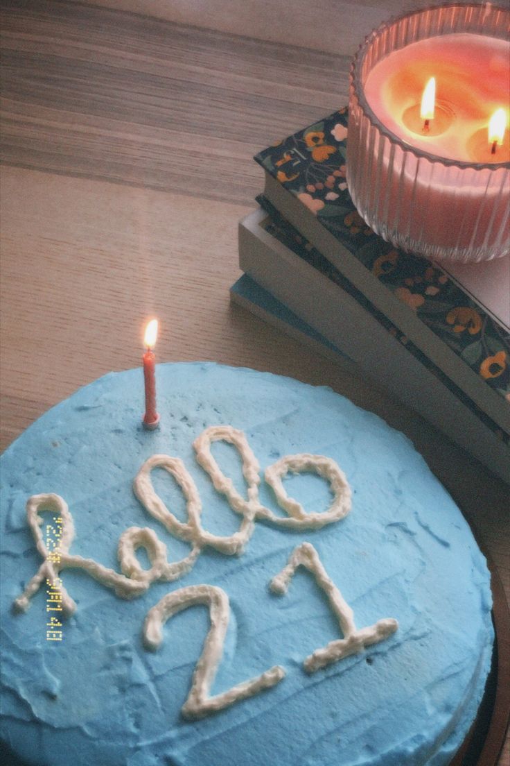 a blue cake with the number twenty two on it and a lit candle next to it