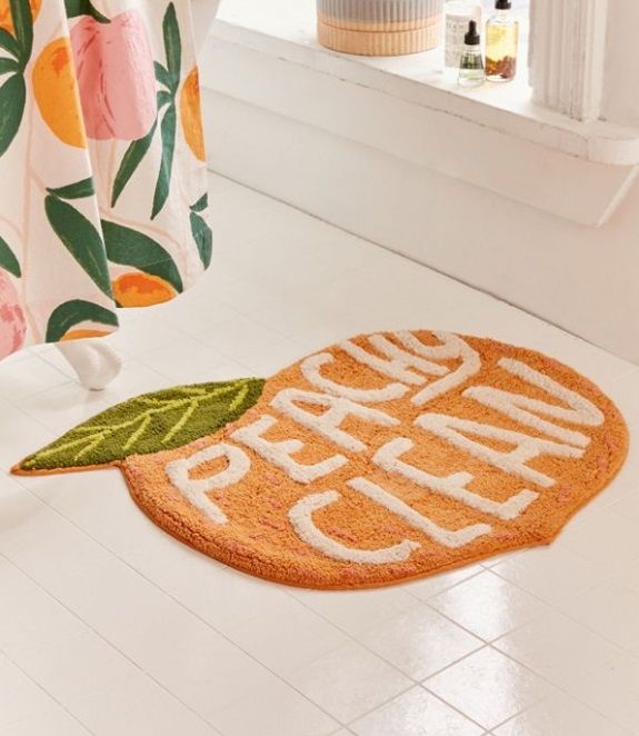 an orange rug on the floor next to a shower curtain