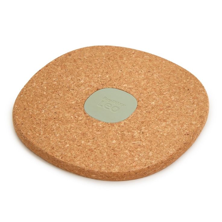 a cork coaster with a green circle on the front and bottom, sitting on a white surface