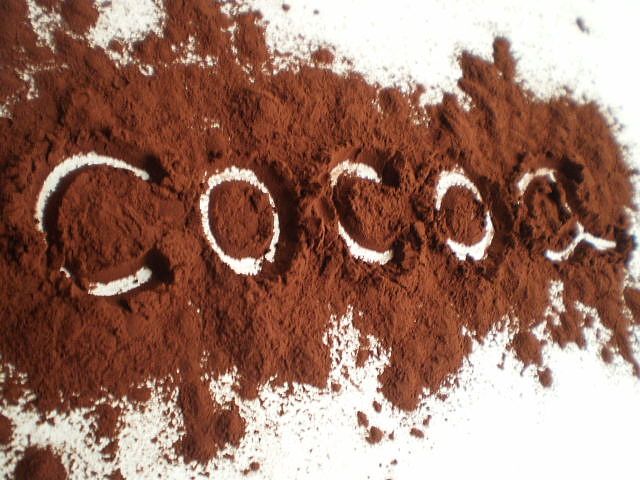 cocoa powder with the word coco written on it in white letters, surrounded by cocoa powder