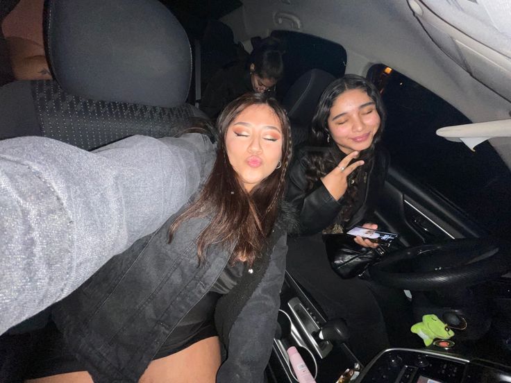 two women sitting in the back seat of a car