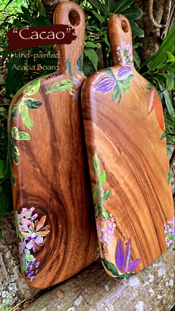 two wooden vases sitting on top of a rock next to some plants and trees