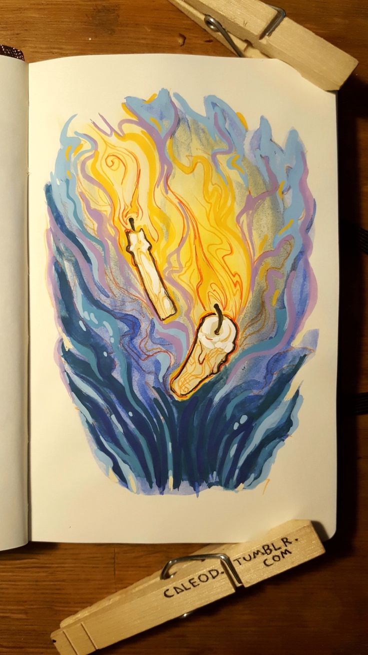 an open book with a drawing of a cross on fire in the middle and flames coming out of it