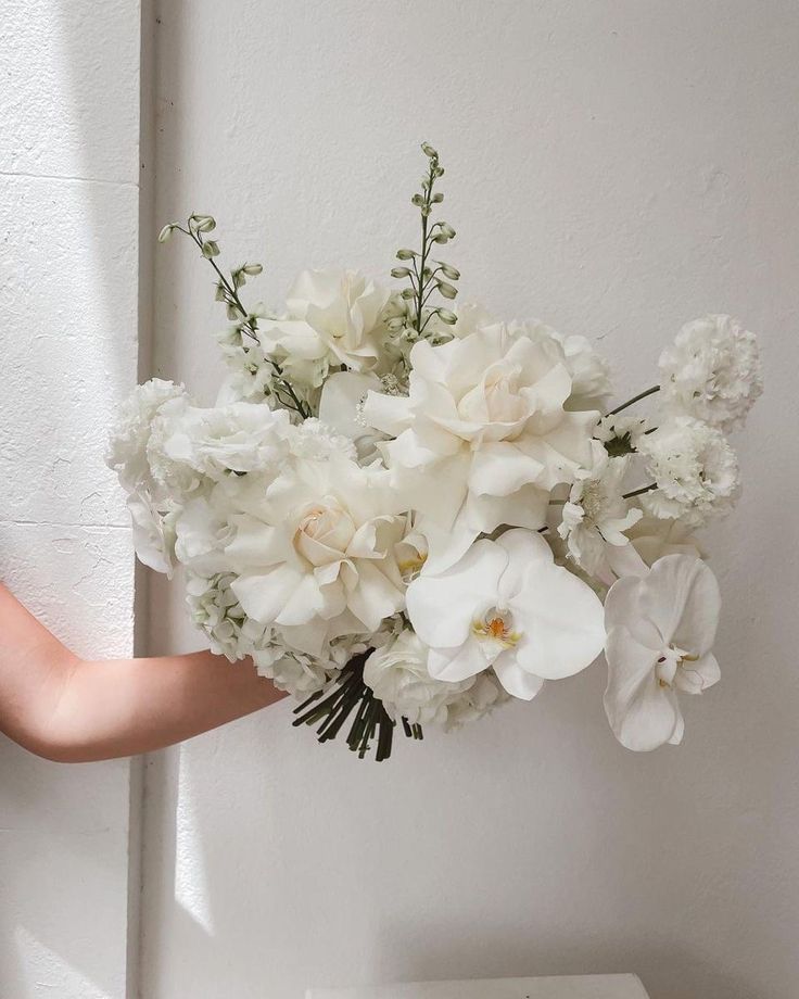 a woman holding a bouquet of white flowers