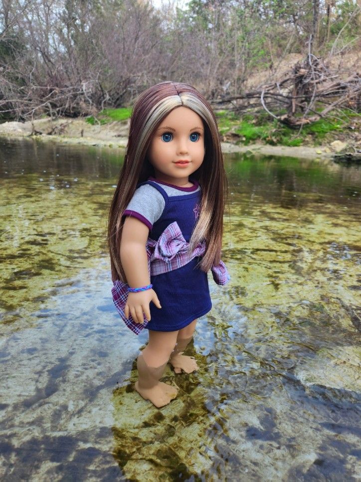 a doll is standing in the shallow water