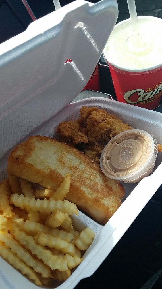 an open takeout container filled with fried chicken and fries