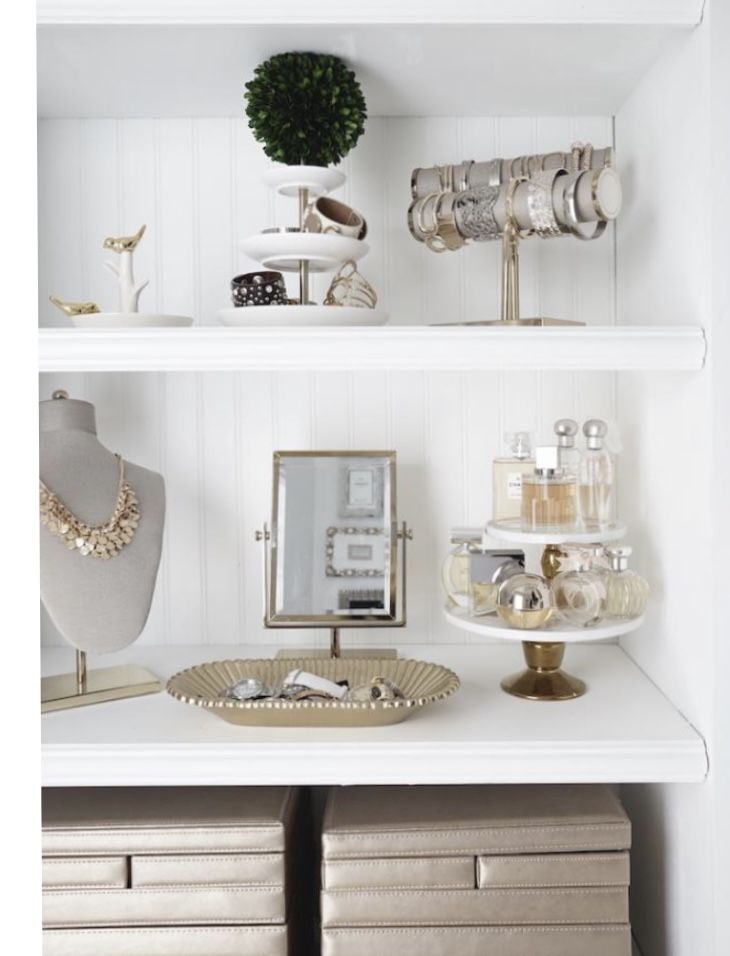 a white shelf filled with jewelry and other items