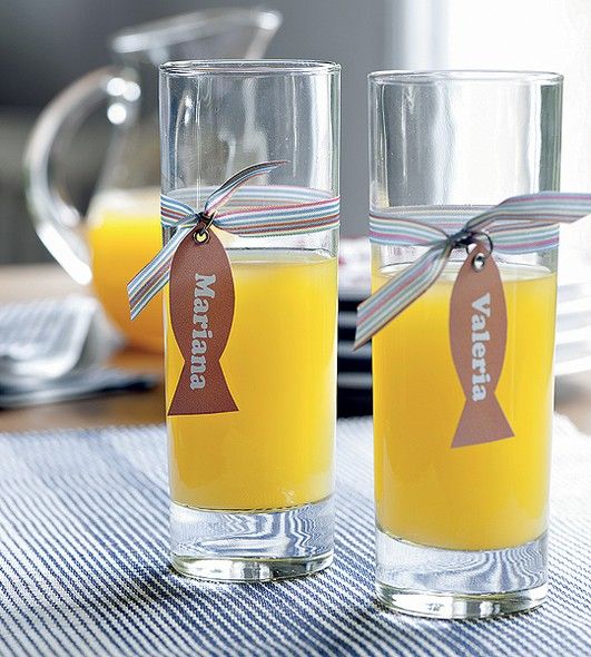 two glasses filled with orange juice sitting on top of a table next to each other