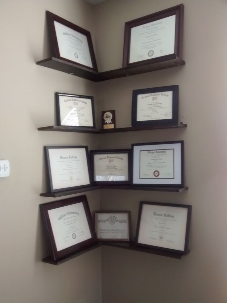 several framed diplomas and plaques are on the wall in this corner, along with an award plaque