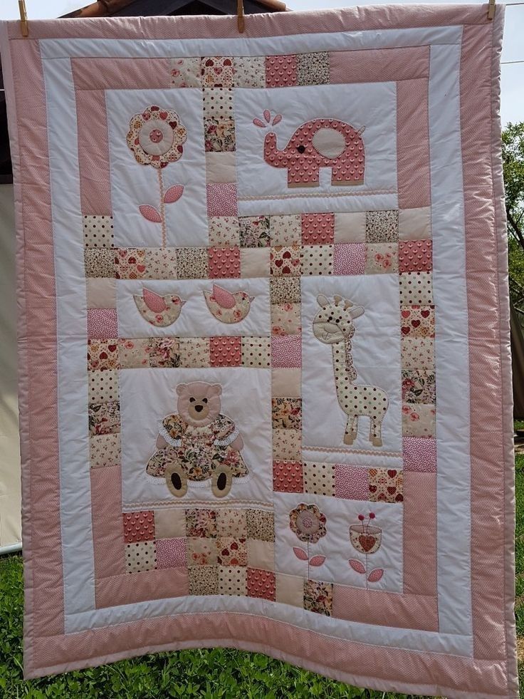 a pink and white quilt hanging from a clothes line