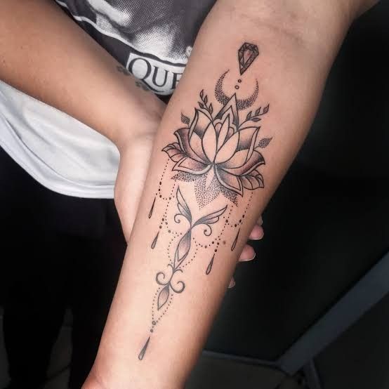 a woman's arm with a flower tattoo on the left side of her arm