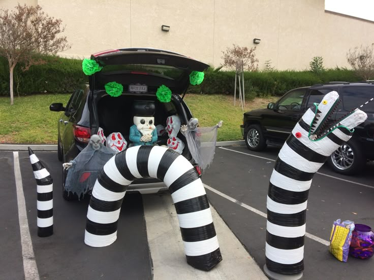 the trunk of a car is decorated with fake black and white striped legs, green eyes, and decorations