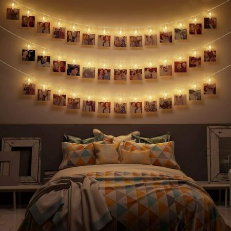 a bed room with a neatly made bed and pictures hanging on the wall above it