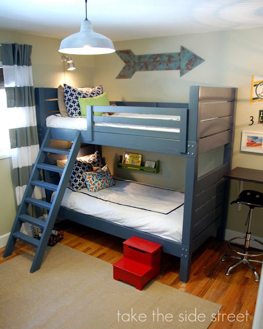 a bunk bed in a child's bedroom with an arrow on the wall above it