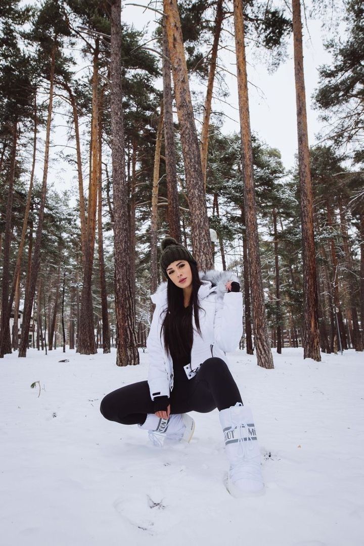 a woman sitting in the snow with her feet up