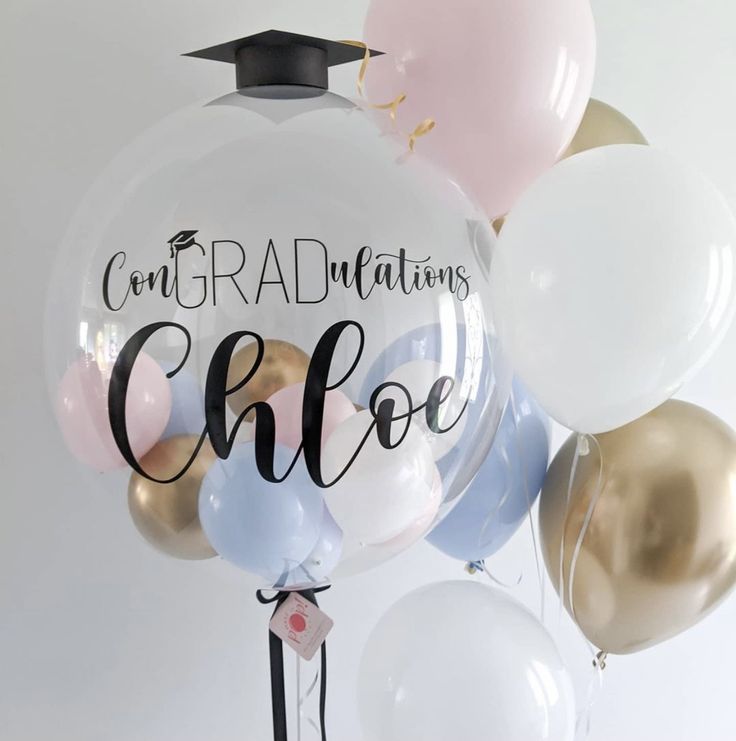 graduation balloons with congratulations written on them and tassels attached to the balloon holder