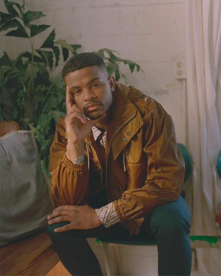 a man sitting on top of a wooden table next to a plant