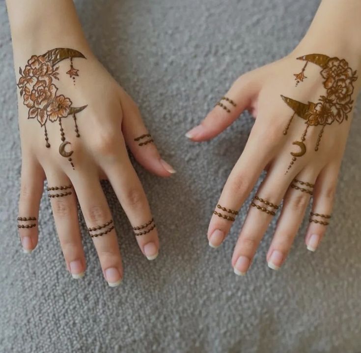 two hands with hendi tattoos on them, one is holding an umbrella and the other has