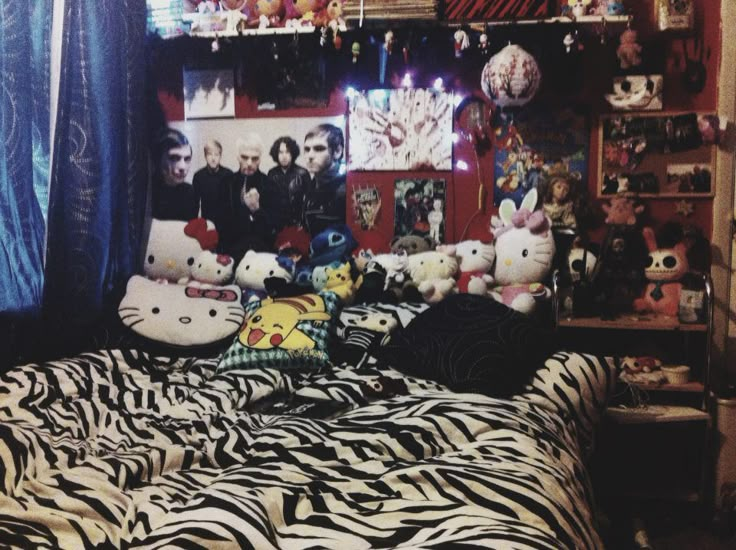 a bed with zebra print sheets and stuffed animals on the headboard in a bedroom