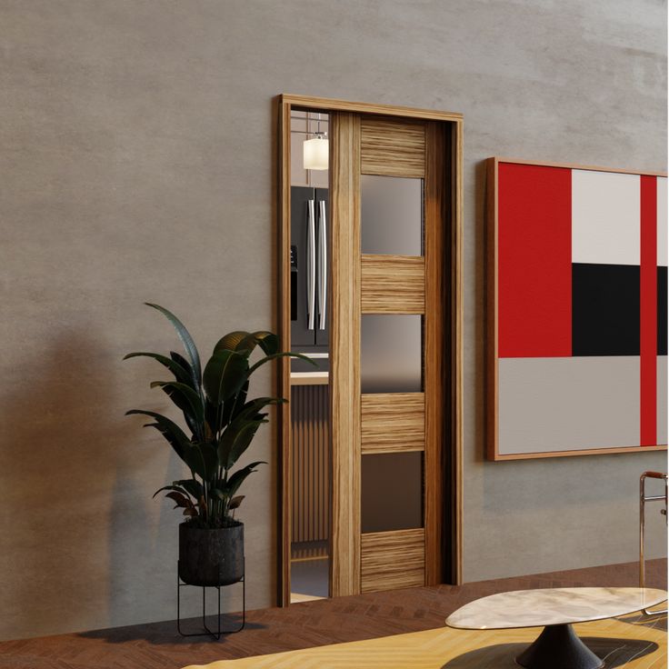 a living room with a potted plant next to a wooden door and two paintings on the wall