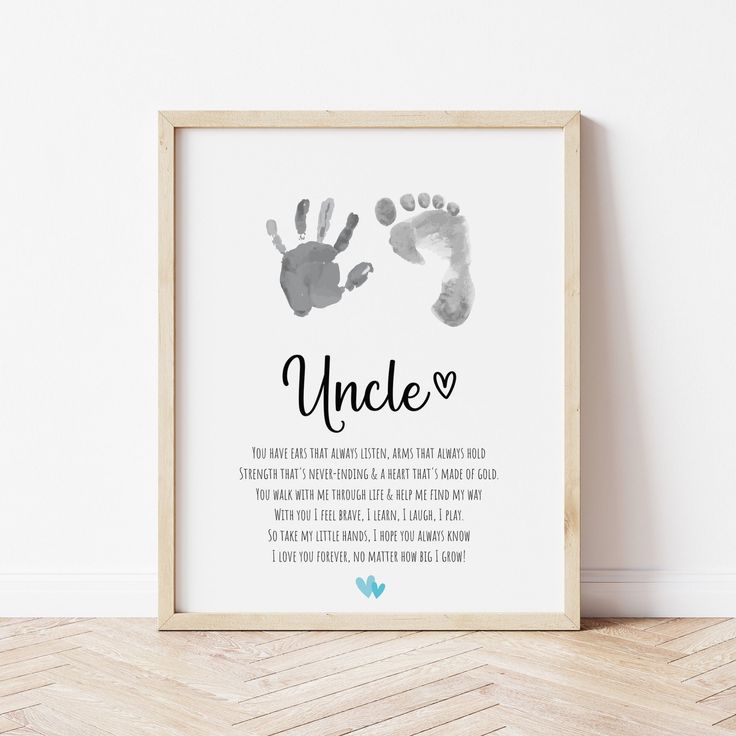 a framed print with the words uncle and two handprints on it, in front of a white wall