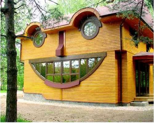 a wooden house with a smiley face on it's side and two round windows