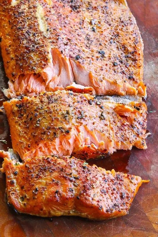 grilled salmon fillets on a cutting board with text overlay saying how to make smoked trout