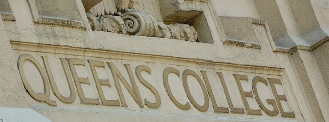 the queen's college sign is on the side of a building