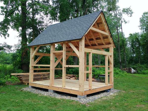 a small wooden structure sitting on top of a lush green field with trees in the background