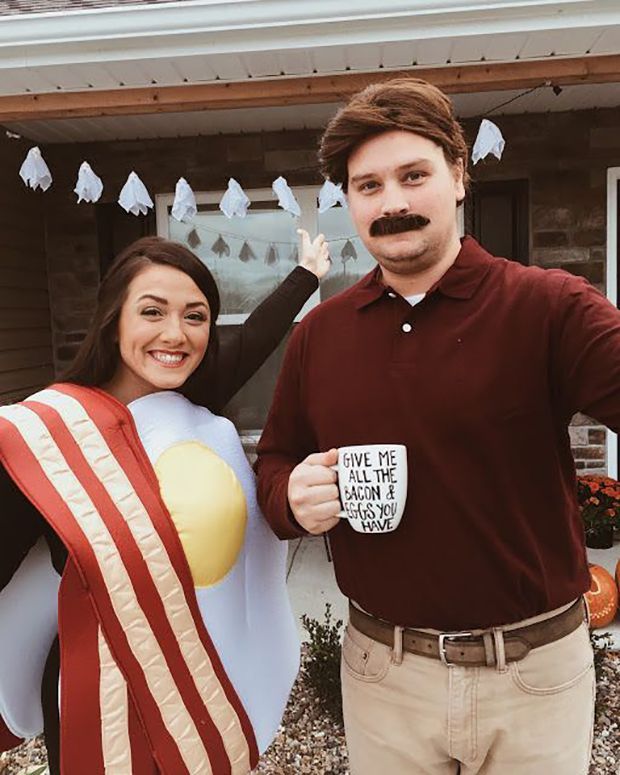 a man and woman dressed up in costumes holding coffee mugs while standing next to each other