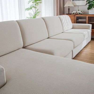 a white couch sitting in front of a window