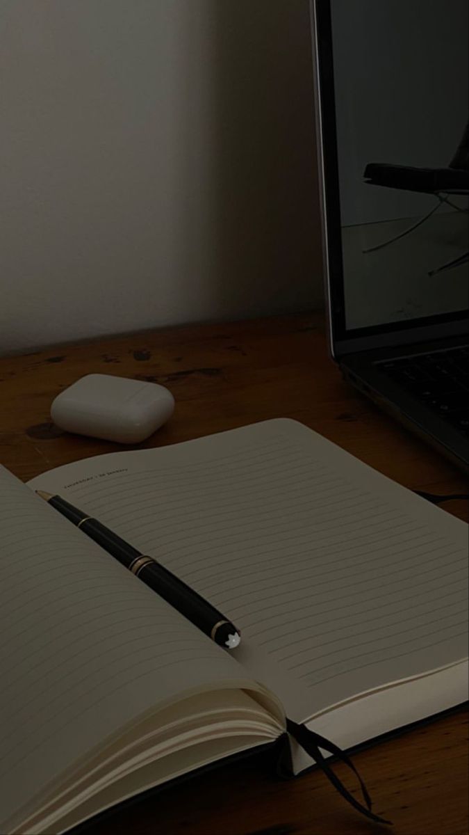 an open notebook sitting on top of a wooden desk