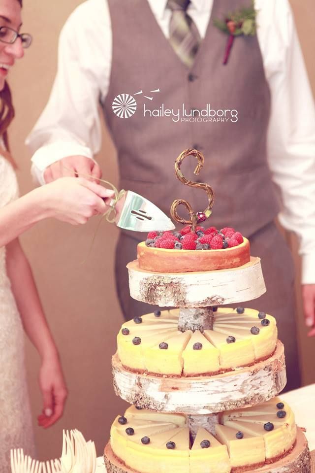 a bride and groom are cutting their wedding cake with a pair of scissors in front of them