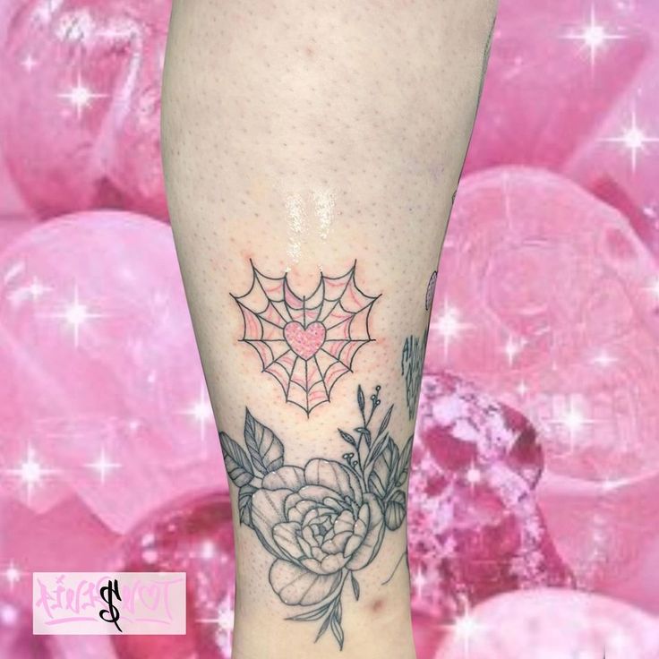 a woman's leg with a spider web and rose tattoo on her left calf