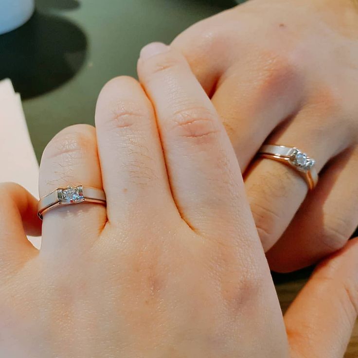 two hands holding each other while wearing wedding rings