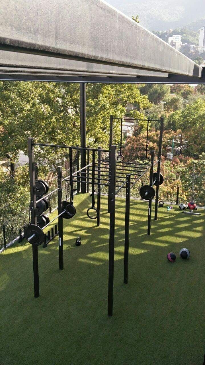 an outdoor gym with several balls on the grass