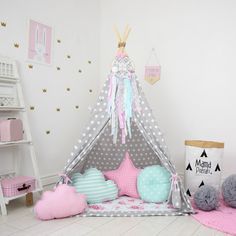 a child's teepee with pillows and decorations