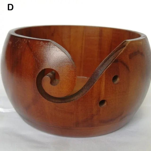 a wooden bowl with an intricate design on the bottom and inside, sitting on a white surface