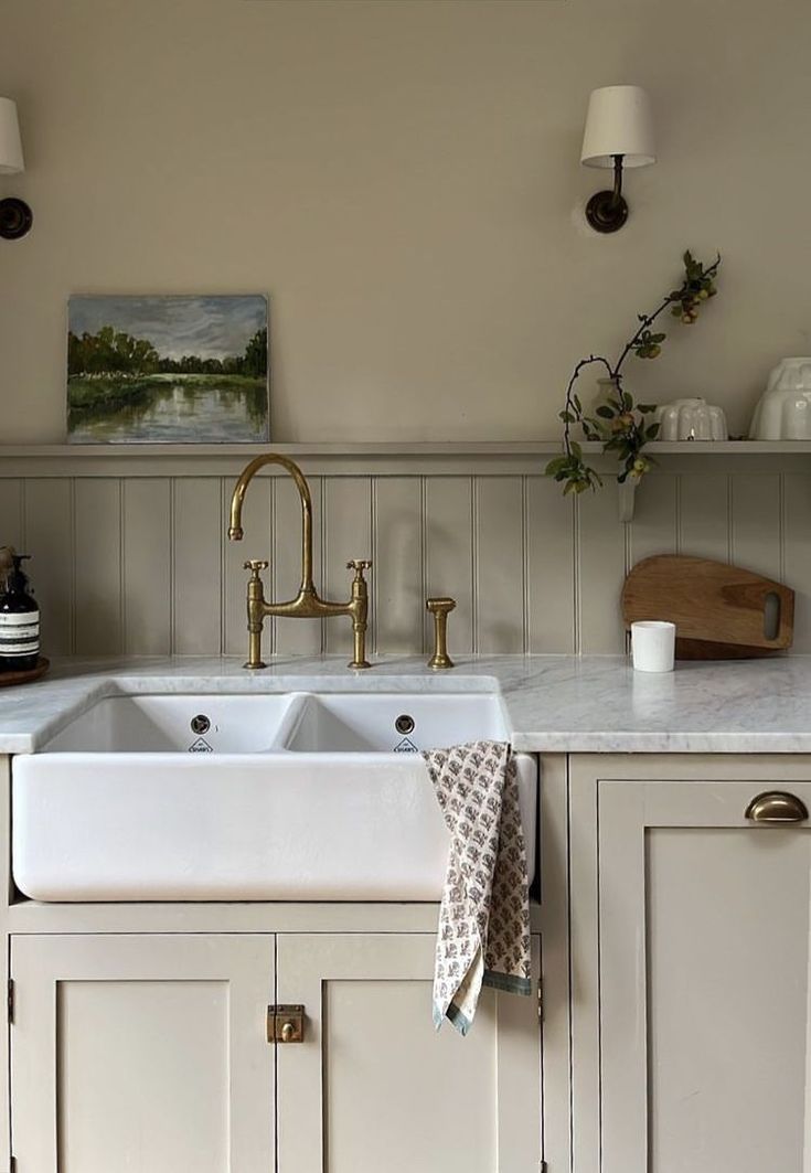 a white kitchen sink sitting under two lights