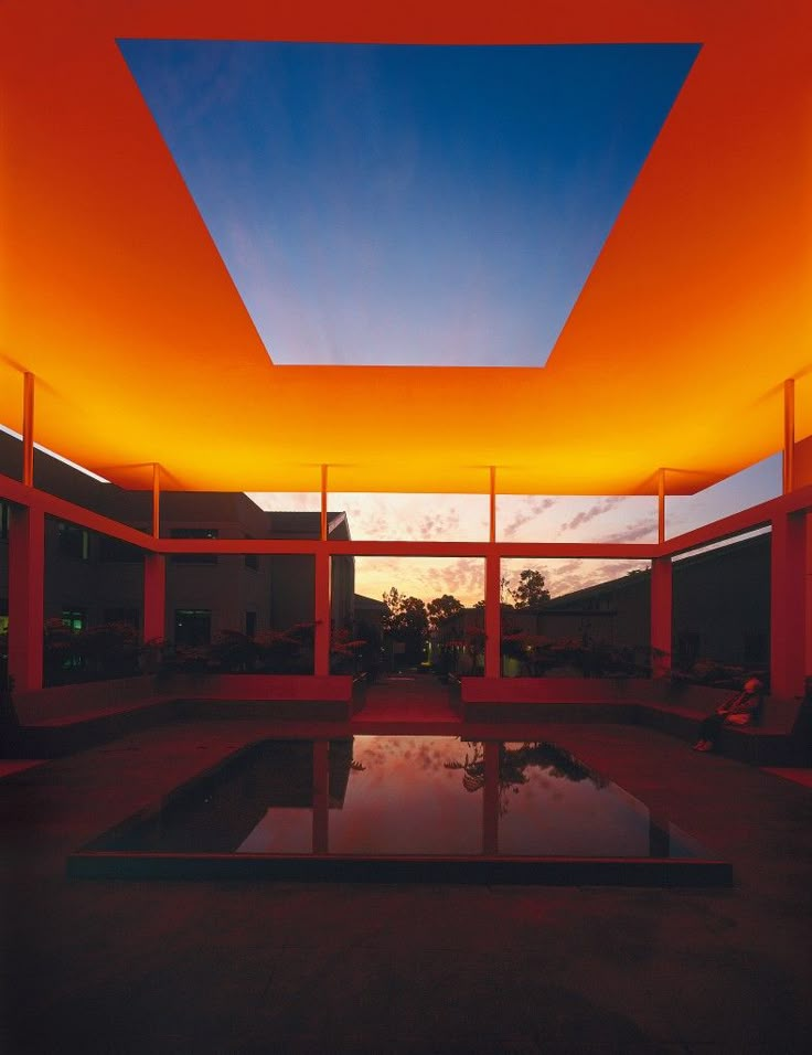 an orange structure with water in the middle and sky above it at sunset or dawn