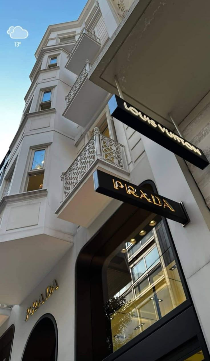 the entrance to an upscale hotel with white walls and black signage on it's side