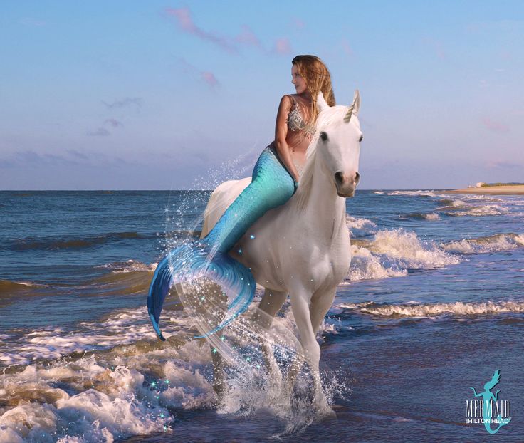 a woman riding on the back of a white horse in the ocean next to waves