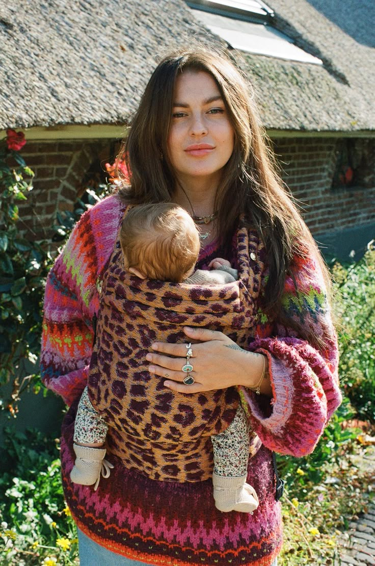 a woman holding a baby wrapped in a blanket