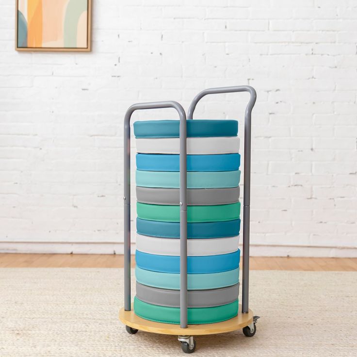 a multicolored container sitting on wheels in front of a white brick wall and floor