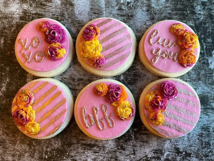 four decorated cookies sitting on top of a table next to each other with the number six