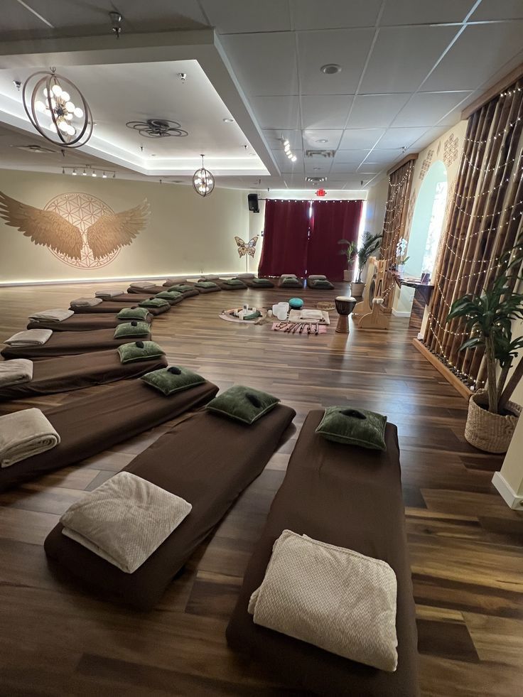 a large room filled with lots of brown and white blankets on top of wooden flooring